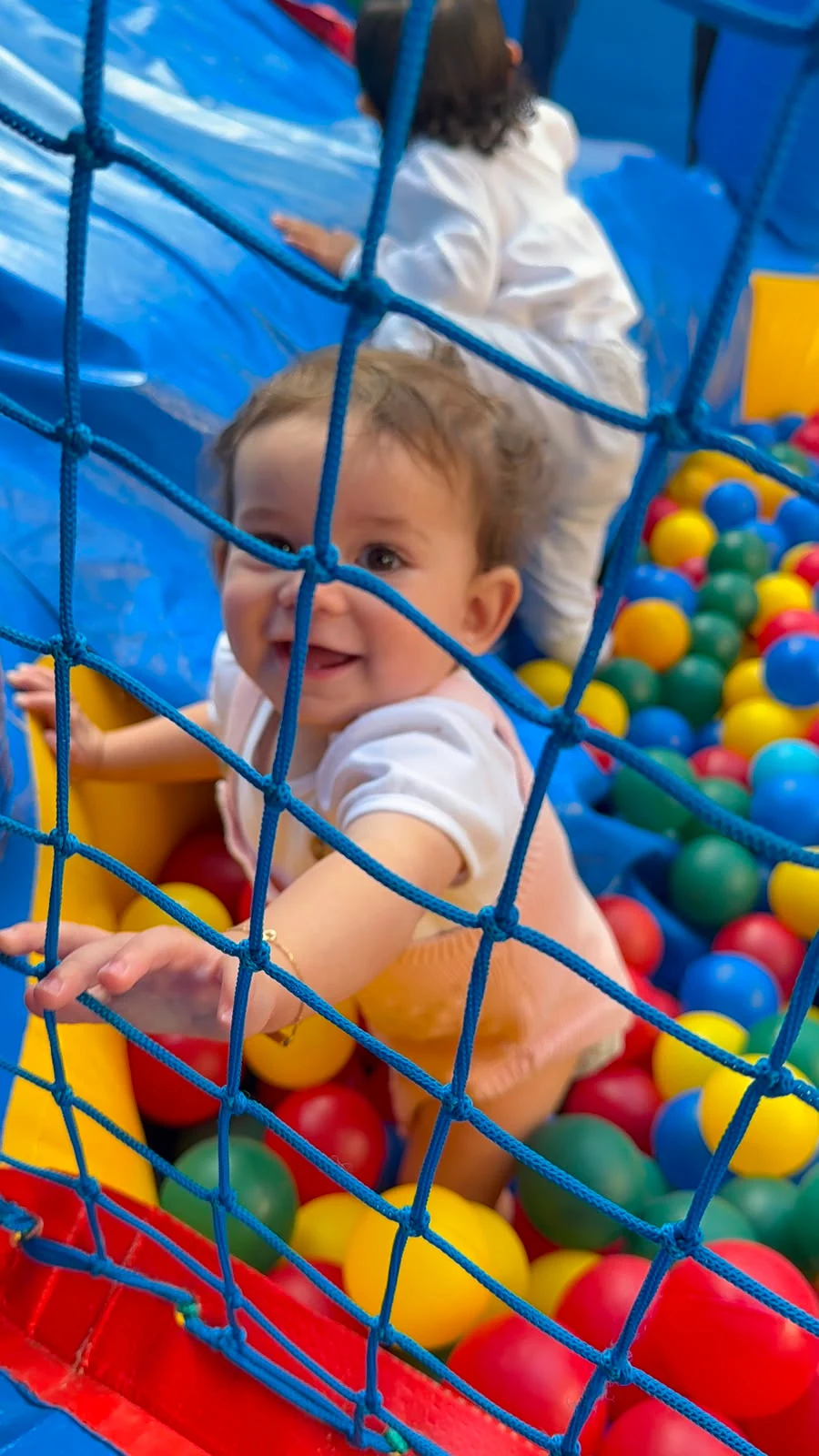Bebê sorrindo na piscina de bolinhas do Berçário da Aussie Education.