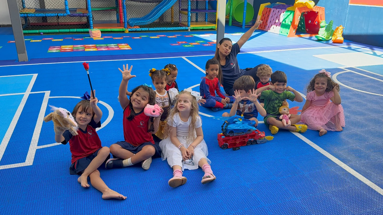Professora da Aussie Education brincando com as crianças em um espaço de movimento.