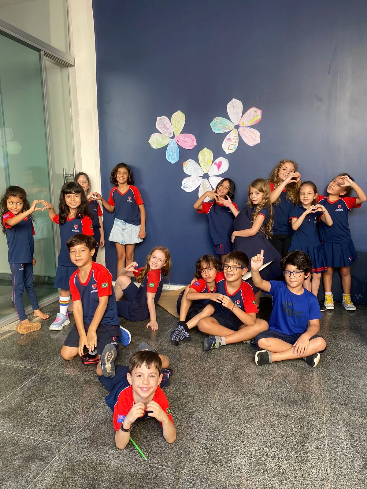 Turma da Aussie Education reunida fazendo corações com as mãos.